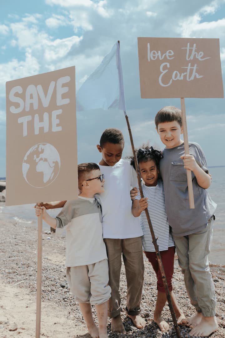 Enfants tenant des pancartes disant "save the world".